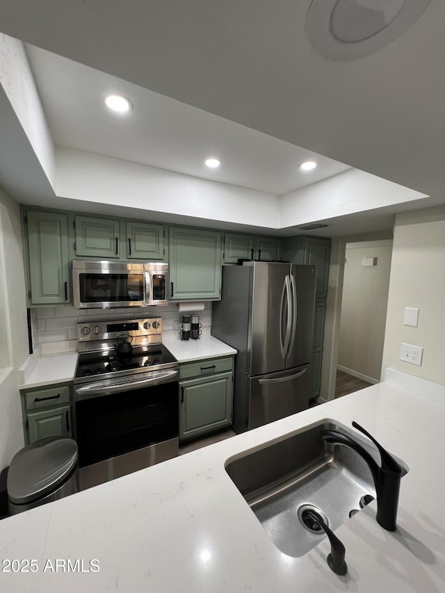 4040 N Weimer Pl Unit 4, Tucson, AZ 85719 - kitchen with a sink, a tray ceiling, green cabinets, light countertops, and appliances with stainless steel finishes