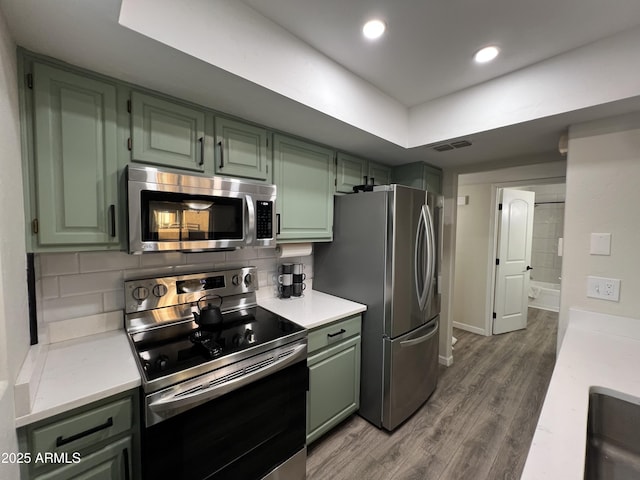 4040 N Weimer Pl Unit 4, Tucson, AZ 85719 - kitchen featuring wood finished floors, stainless steel appliances, visible vents, green cabinets, and light countertops