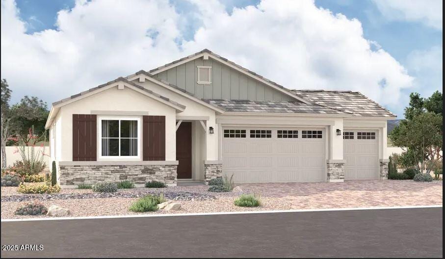 craftsman inspired home with an attached garage, stone siding, decorative driveway, and board and batten siding