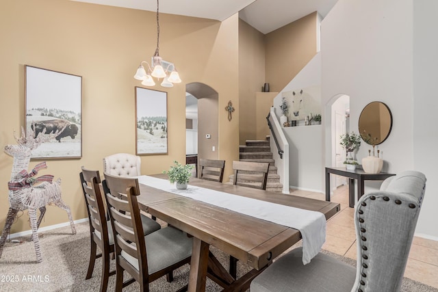 12376 W Hazelwood St, Avondale, AZ 85392 - dining area with an inviting chandelier, arched walkways, a high ceiling, stairs, and baseboards