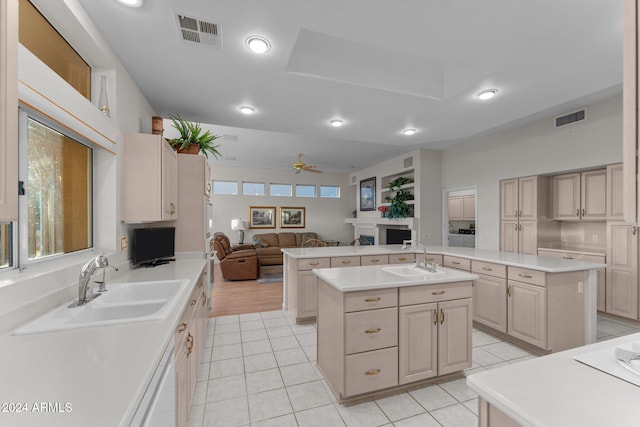 kitchen featuring light tile patterned flooring, a center island with sink, ceiling fan, and sink