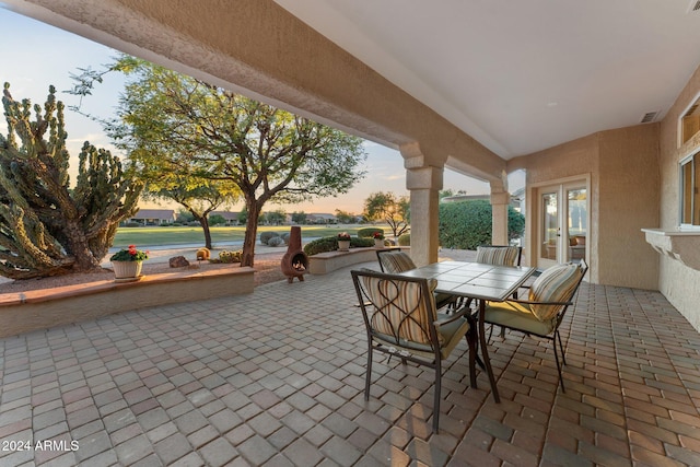 patio terrace at dusk with a water view and french doors