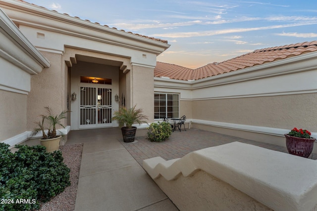 exterior entry at dusk with a patio area