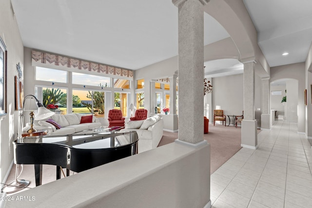 living room with decorative columns and light colored carpet