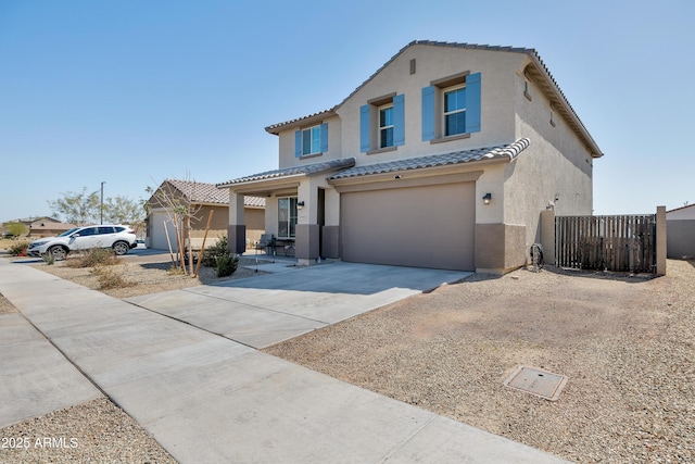 mediterranean / spanish-style house featuring fence, a tiled roof, concrete driveway, stucco siding, and an attached garage