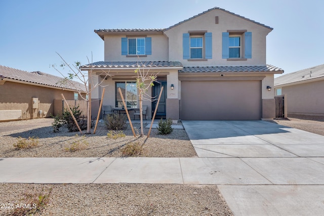 view of front of property featuring a tiled roof, stucco siding, driveway, and a garage