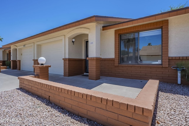 view of front of house with stucco siding, an attached garage, and driveway