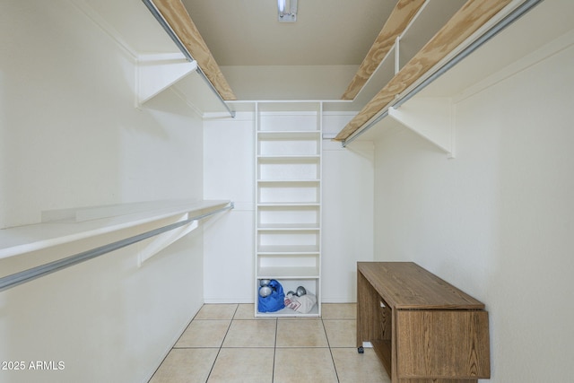 walk in closet with light tile patterned floors
