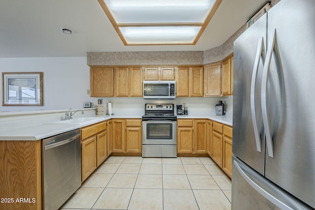 kitchen featuring appliances with stainless steel finishes, a sink, light tile patterned floors, and light countertops