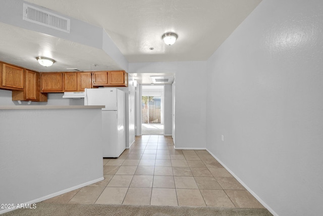 kitchen with white fridge and light tile patterned flooring