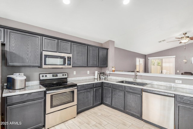 kitchen featuring appliances with stainless steel finishes, vaulted ceiling, sink, and ceiling fan