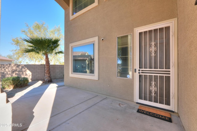 view of exterior entry with a patio