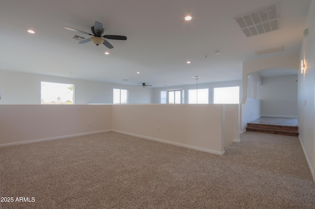 empty room featuring ceiling fan and light carpet