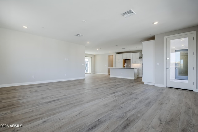 2121 W Sonoran Desert Dr Unit 43, Phoenix, AZ 85085 - unfurnished living room with light wood finished floors, a sink, baseboards, and recessed lighting
