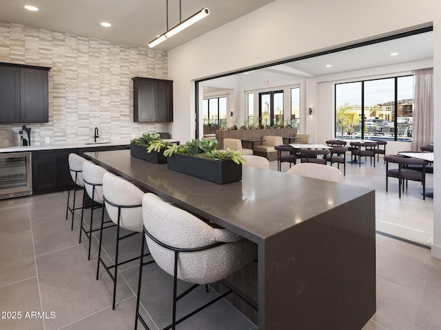 2121 W Sonoran Desert Dr Unit 43, Phoenix, AZ 85085 - kitchen with beverage cooler, a sink, a breakfast bar, light tile patterned flooring, and recessed lighting