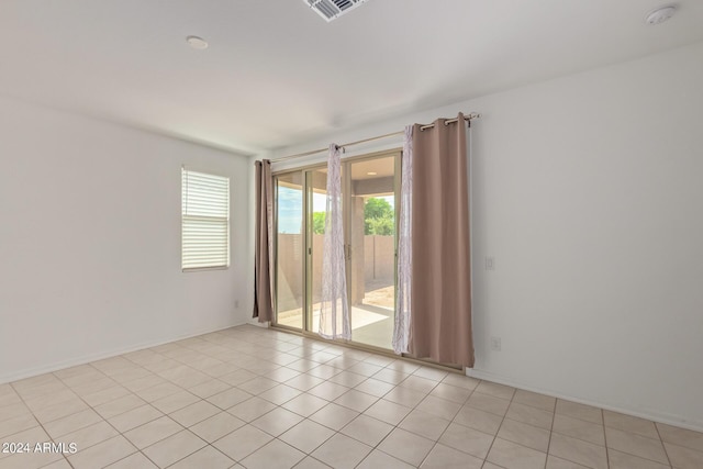 empty room with light tile patterned floors and visible vents