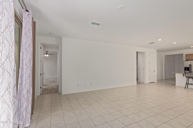 unfurnished living room featuring light tile patterned floors and ceiling fan