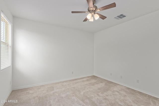 empty room with light carpet, visible vents, baseboards, and a ceiling fan