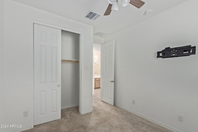 unfurnished bedroom featuring light colored carpet, a closet, and ceiling fan