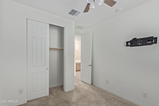 unfurnished bedroom featuring visible vents, baseboards, light carpet, a closet, and a ceiling fan