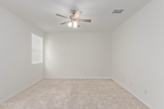 unfurnished room featuring ceiling fan, baseboards, visible vents, and light carpet