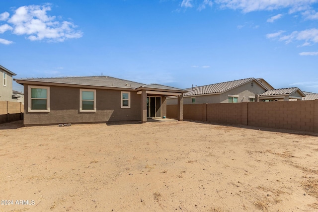 back of property with stucco siding and a fenced backyard