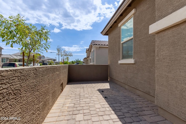 exterior space with a residential view, stucco siding, a tiled roof, and a balcony