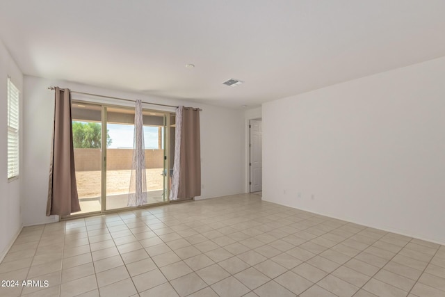 spare room featuring light tile patterned floors and visible vents