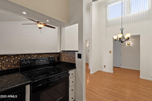 kitchen with ceiling fan with notable chandelier, tasteful backsplash, white cabinetry, light hardwood / wood-style floors, and black range with electric cooktop