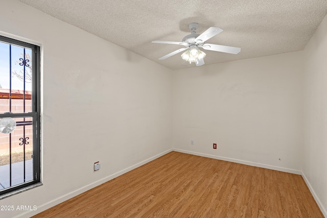 empty room with ceiling fan, a textured ceiling, and light hardwood / wood-style floors