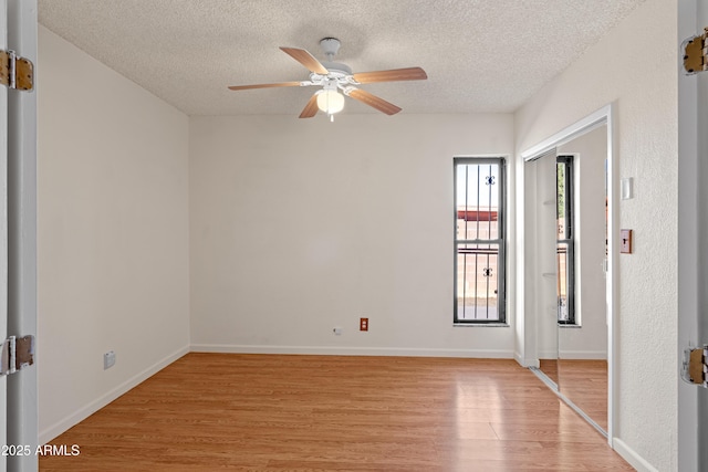 unfurnished room with ceiling fan, a textured ceiling, and light hardwood / wood-style flooring