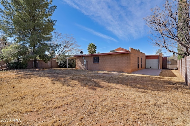 back of property with a garage and a yard