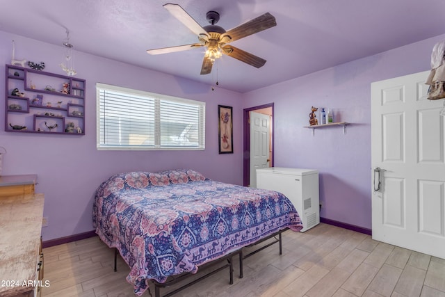 bedroom with light hardwood / wood-style flooring, fridge, and ceiling fan