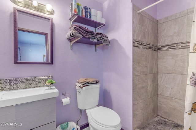 bathroom featuring tasteful backsplash, vanity, toilet, and a tile shower