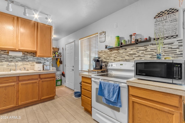 kitchen with tasteful backsplash, white range with electric cooktop, and sink