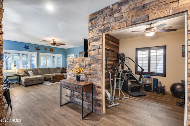 interior space featuring visible vents, wood finished floors, ceiling fan, and a textured ceiling