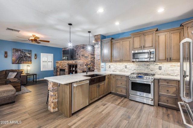 kitchen with open floor plan, a sink, stainless steel appliances, and visible vents