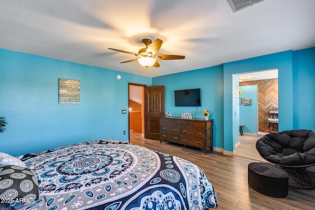 bedroom with baseboards, visible vents, wood finished floors, and a ceiling fan