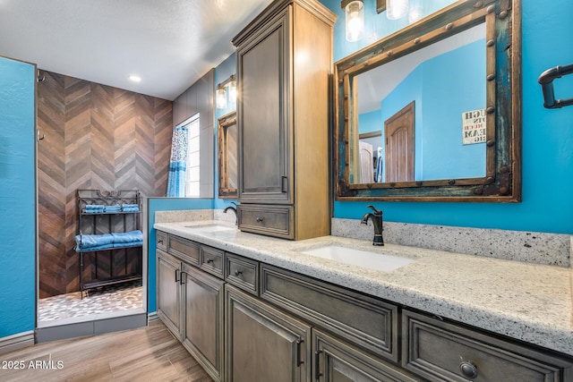 bathroom featuring double vanity, a sink, and wood finished floors