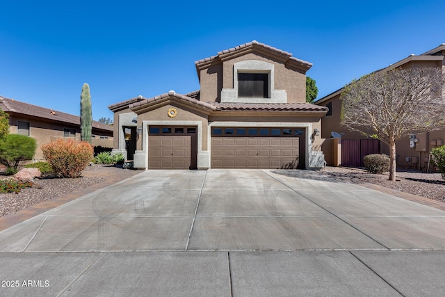 mediterranean / spanish home with a tiled roof, concrete driveway, stucco siding, and an attached garage