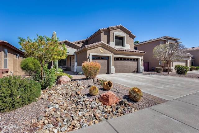 mediterranean / spanish house featuring driveway, stucco siding, a tile roof, and an attached garage