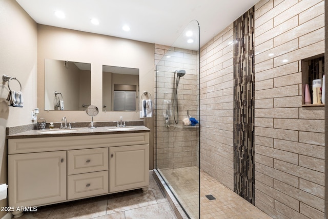 bathroom featuring tiled shower, vanity, and tile patterned floors