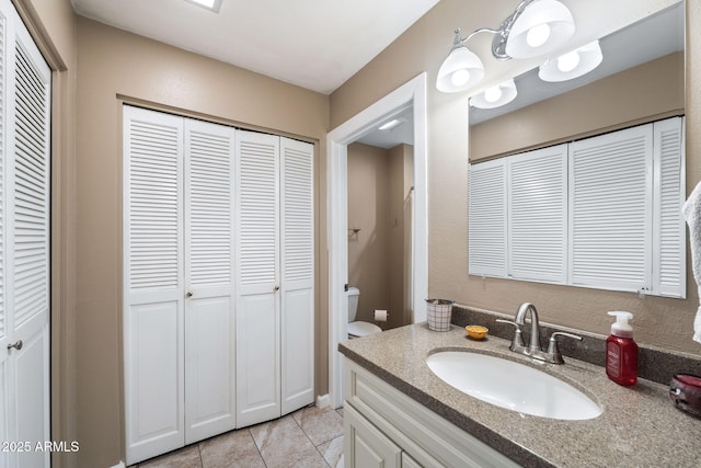 bathroom featuring tile patterned floors, vanity, and toilet