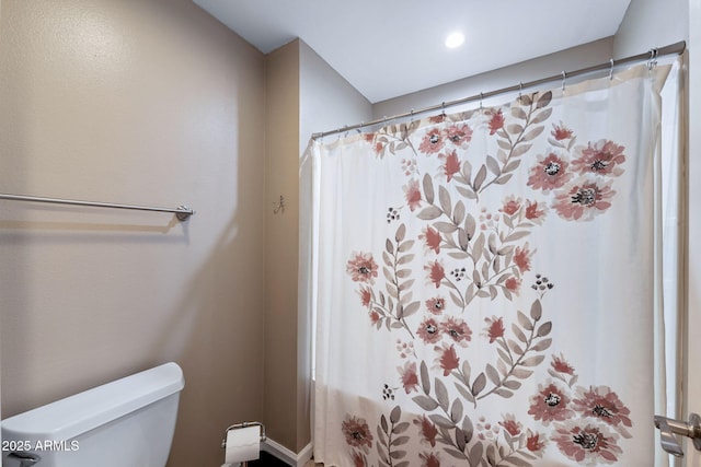 bathroom featuring a shower with curtain and toilet