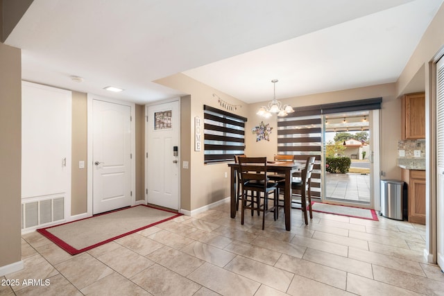 dining space featuring light tile patterned floors and a notable chandelier