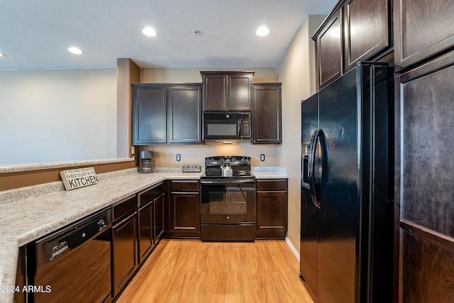 kitchen with dark brown cabinetry, black appliances, and light wood-type flooring