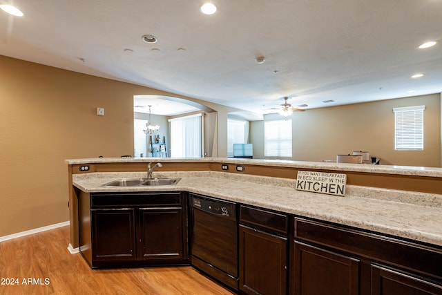 kitchen featuring light stone countertops, ceiling fan with notable chandelier, sink, black dishwasher, and light hardwood / wood-style floors