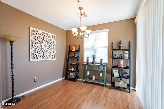 misc room with hardwood / wood-style flooring and an inviting chandelier