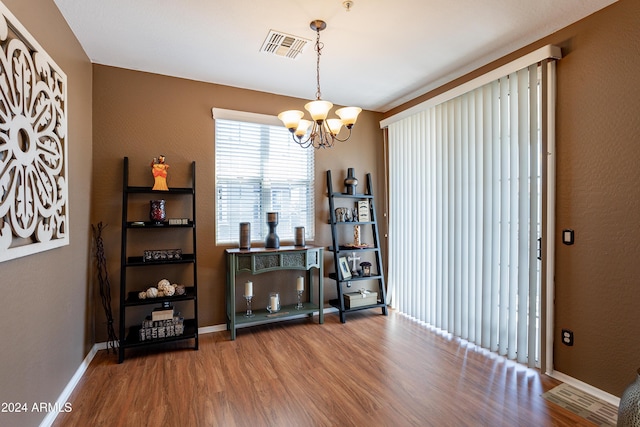 misc room with wood-type flooring and an inviting chandelier