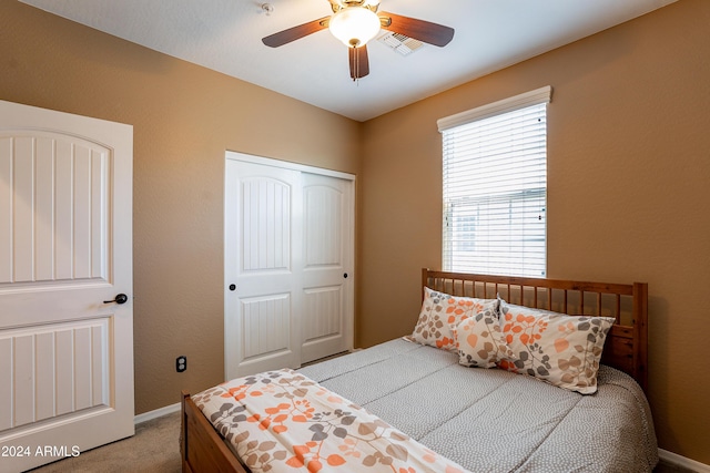 carpeted bedroom featuring ceiling fan and a closet